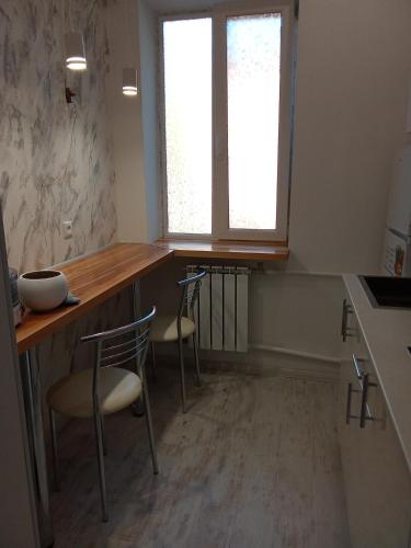 a kitchen with two chairs and a wooden counter top at Ботанічний Сад in Kharkiv