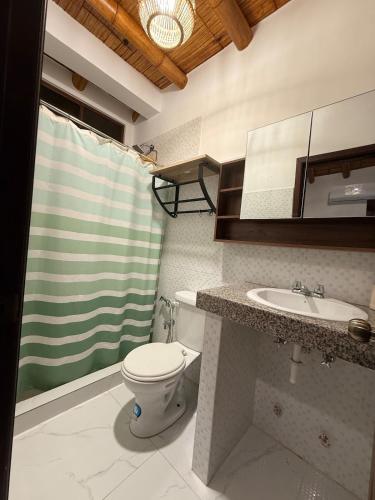 a bathroom with a toilet and a sink at Casa Vacacional Valles de Olon in Santa Elena
