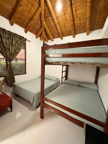 two bunk beds in a room with a window at Casa Vacacional Valles de Olon in Santa Elena