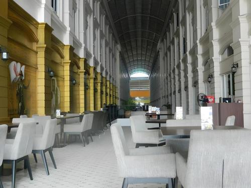 a hallway with white chairs and tables in a building at Wing Hotel Kualanamu Airport in Medan