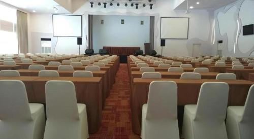 a large room with rows of tables and chairs at Wing Hotel Kualanamu Airport in Medan