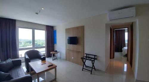 a living room with a couch and a table at Wing Hotel Kualanamu Airport in Medan