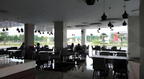 a restaurant with tables and people sitting at tables at Wing Hotel Kualanamu Airport in Medan