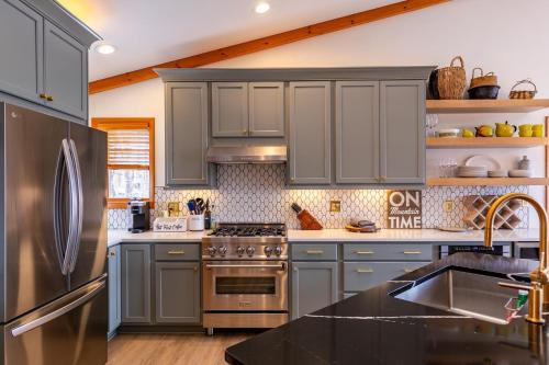 a kitchen with gray cabinets and a stainless steel refrigerator at The Raven in Beech Mountain