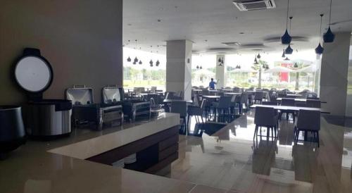 a dining area with tables and chairs in a restaurant at Wing Hotel Kualanamu Airport in Medan