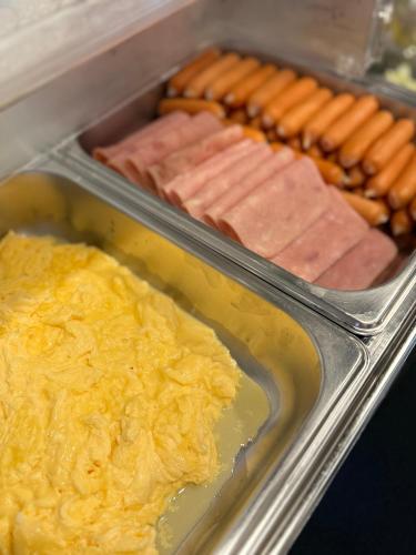a tray of food with hot dogs and other foods at Blu Monkey Hub & Hotel Surat Thani in Surat Thani