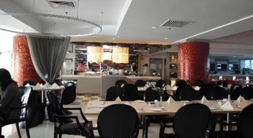 a dining room with tables and chairs and a bar at The CentrePoint Hotel in Bandar Seri Begawan