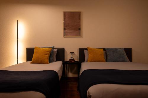 two beds sitting next to each other in a room at BREEZE furano 202 in Furano