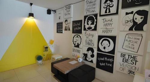 a room with a couch and posters on the wall at U Style Hotel in Sakon Nakhon