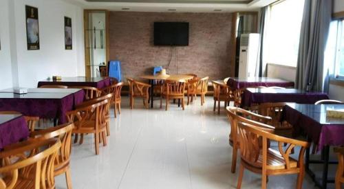 a dining room with tables and chairs and a tv at Super 8 Hotel Fuzhou Jinjishan in Fuzhou