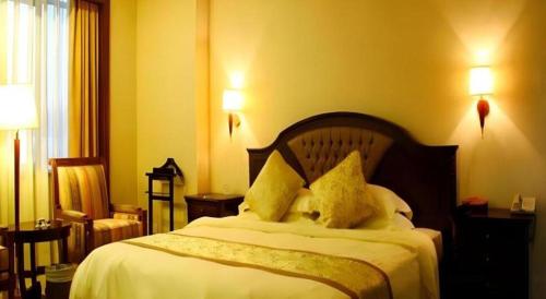 a bedroom with a bed with two pillows on it at Quanzhou Royal Prince Hotel in Quanzhou