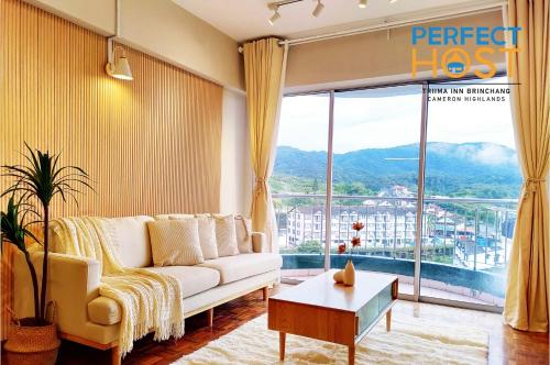 a living room with a couch and a large window at Triima Inn Brinchang by Perfect Host in Brinchang