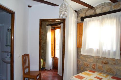 1 dormitorio con 1 cama y baño con ventana en Casa Yayo, en La Pobla de Benifassà (Puebla de Benifasar)