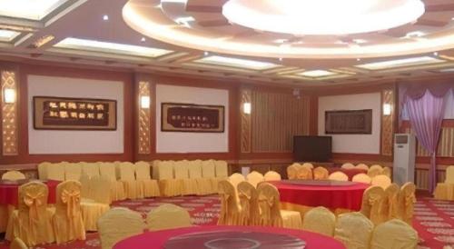a large room with chairs and tables and a tv at Jintone Hotel Beiliu Yongan Branch in Yulin