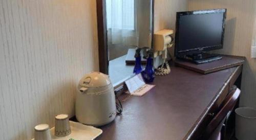 a desk with a computer on top of it at Hotel Town Nishikigawa in Kochi