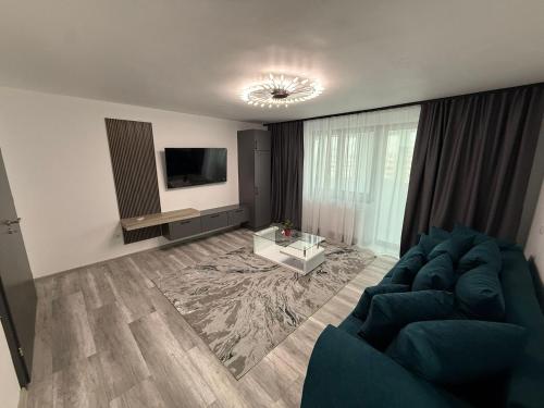 a living room with a blue couch and a tv at Happy House in Craiova