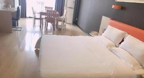 a large bed in a room with a table at 7 Days Premium Jingjiang Fuhai New World Automobile Terminal Branch in Jingjiang