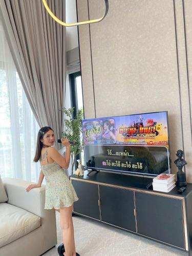 a young girl standing in a living room playing a video game at I-DIN POOL VILLA khaoyai in Ban Nong Song Hong