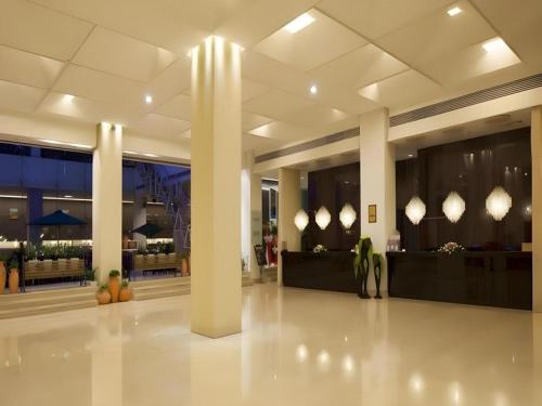 a lobby with columns and tables in a building at Catic Hotel--Adjacent Buliding in Zhuhai