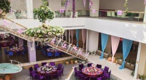 a banquet hall with purple chairs and tables and flowers at Catic Hotel--Adjacent Buliding in Zhuhai