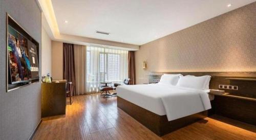 a hotel room with a large white bed and a desk at James Joyce Coffetel Chengdu Jianshe Road Dongjiao Jiyi Square in Chengdu