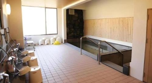 a bathroom with a tub and sinks in a room at Yunosawa Onsen Mori no Shiki in Shimukappu