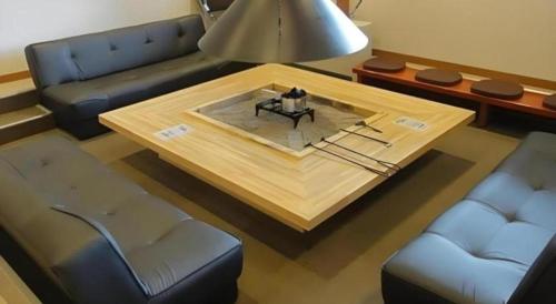 a living room with a couch and a coffee table at Yunosawa Onsen Mori no Shiki in Shimukappu