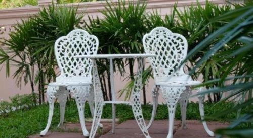 two white chairs sitting next to a table at Pharadhevi in Ban Dung