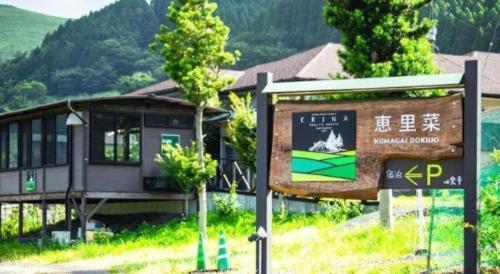 a sign in front of a building with a train at Yufuin Tsukahara Villa ERINA in Yufuin