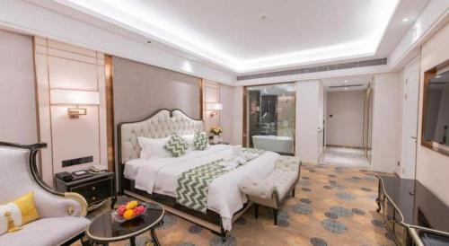 a bedroom with a large white bed and a couch at Enping Yucca Hotel in Enping