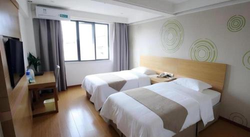 a hotel room with two beds and a television at GreenTree Inn Xuancheng Jingxian Wannan First Street Express Hotel in Xuanzhou