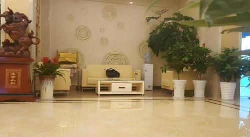 a lobby with potted plants in a building at GreenTree Inn Xuancheng Jingxian Wannan First Street Express Hotel in Xuanzhou