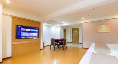 a hotel room with a bed and a table and chairs at GreenTree Inn Xuancheng Jingxian Wannan First Street Express Hotel in Xuanzhou