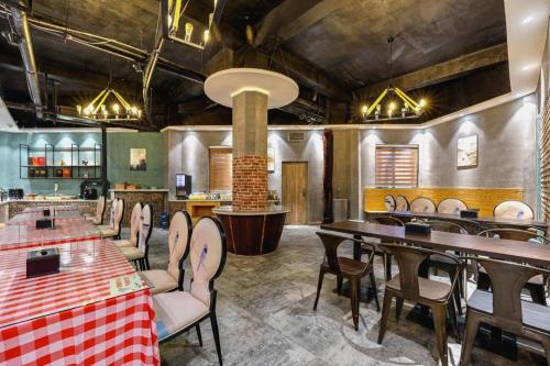 a restaurant with tables and chairs in a room at James Joyce Coffetel Qufu Tourist Center Gulou Street Sankong Scenic Spot in Jining