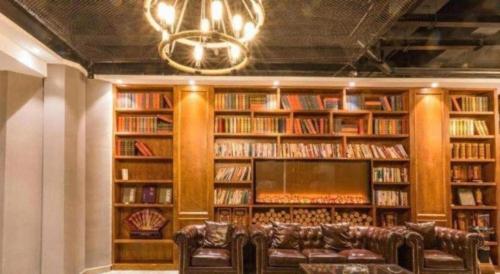 a library with leather couches and a chandelier at James Joyce Coffetel Qufu Tourist Center Gulou Street Sankong Scenic Spot in Jining