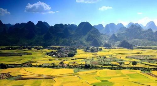 an aerial view of a field with mountains in the background at 7 Days Inn Xingyi Wanfenglin Xiawutun in Xiawutun