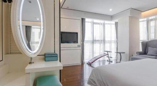 a bedroom with a mirror and a bed and a chair at Xana Lite Anqing Yuexi Swan Squre Branch in Yuexi