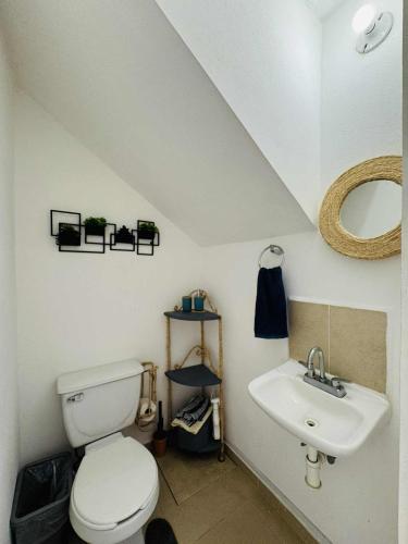 a bathroom with a toilet and a sink at Casa con alberca cerca de playas in Ixtapa