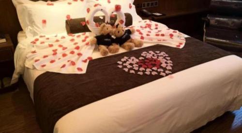 a bed with two teddy bears sitting on top of it at James Joyce Coffetel·Beijing Yizhuang Development Zone Dazu Square Tongji Road in Beijing