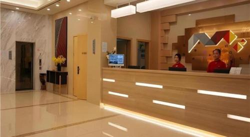 a lobby of a hospital with two people standing behind a counter at Borrman Hotel Zhanjiang Shimao Building High-speed Railway Station in Zhanjiang