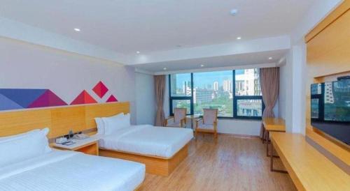 a hotel room with two beds and a large window at Borrman Hotel Zhanjiang Shimao Building High-speed Railway Station in Zhanjiang