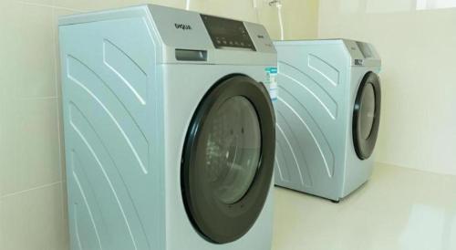 a washing machine and a dryer in a room at Echarm Hotel Zibo Gaoqing Zhongcheng Inernational in Zibo
