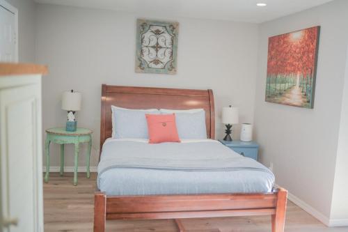 a bedroom with a bed with a orange pillow on it at Charming and Private Birch Cottage in Idaho Falls