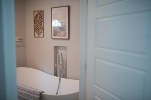 a bathroom with a tub and a mirror at Charming and Private Birch Cottage in Idaho Falls