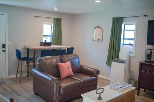 a living room with a leather chair and a table at Charming and Private Birch Cottage in Idaho Falls