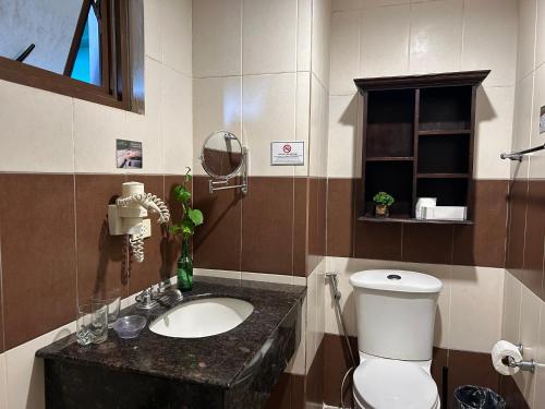 une salle de bain avec des toilettes blanches et un lavabo dans l'établissement Crosswinds Resort Studio Double Suite, à Ulot