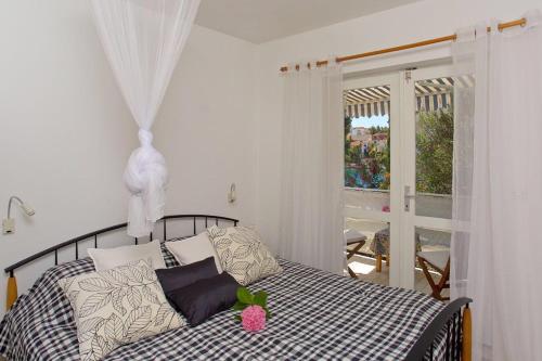 a bedroom with a bed with pillows and a window at Villa Hedonica in Zaboric