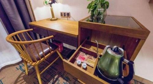 a desk with a chair and a tea kettle on it at James Joyce Coffetel Changchun People's Square in Changchun