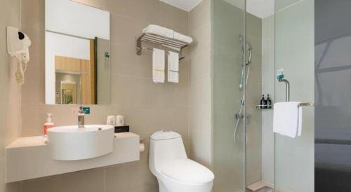a white bathroom with a sink and a shower at City Comfort Inn Dongguan Zhongtang in Guangzhou