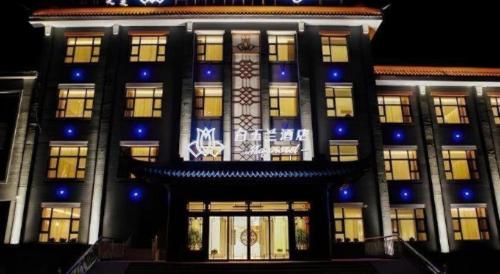 a building with blue lights on the front of it at Magnotel Wulanhaote Hanshan Dong Street in Ulan Hot